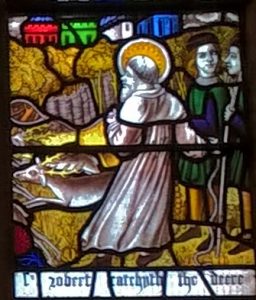 Stained glass window depicting a scene from the life of St Robert